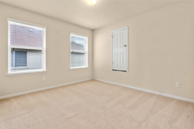 unfurnished room featuring light carpet