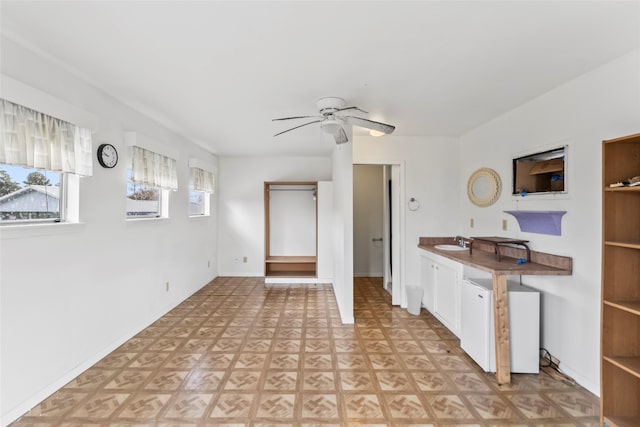 kitchen featuring white cabinets, light parquet floors, ceiling fan, and sink