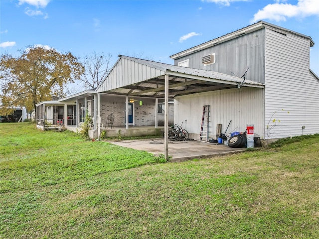 back of house featuring a sunroom, a patio area, and a lawn