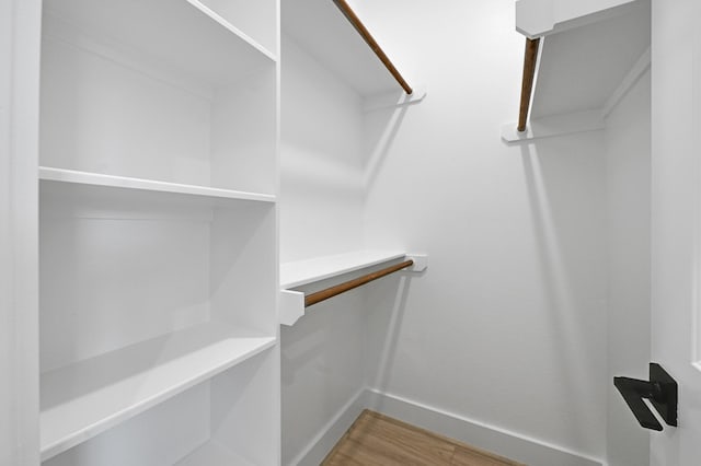 walk in closet with hardwood / wood-style flooring