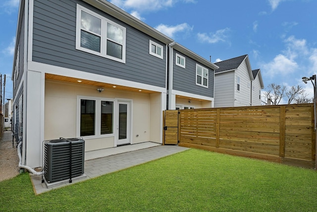 back of property featuring central air condition unit, a patio area, and a lawn