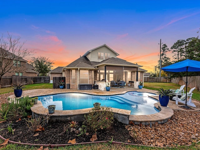 pool at dusk with a patio area