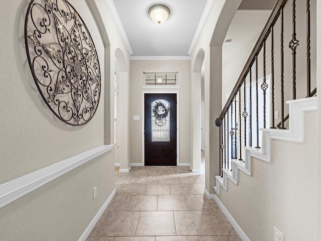 entrance foyer with crown molding and light tile patterned floors