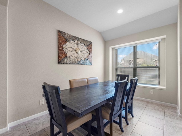 dining space featuring light tile patterned floors and lofted ceiling