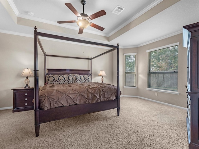 carpeted bedroom with ceiling fan, a raised ceiling, and crown molding