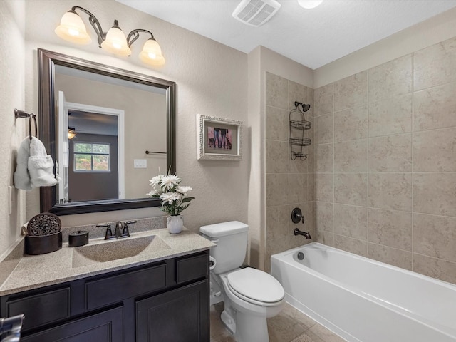 full bathroom with toilet, a textured ceiling, tile patterned flooring, vanity, and tiled shower / bath