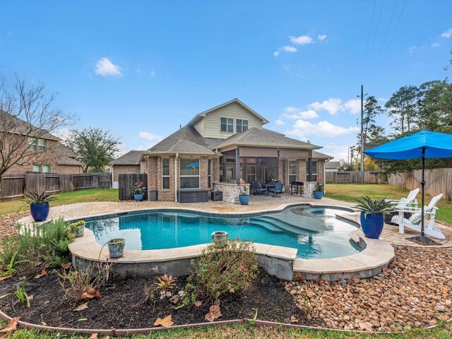 view of swimming pool featuring an in ground hot tub, a patio area, and a sunroom