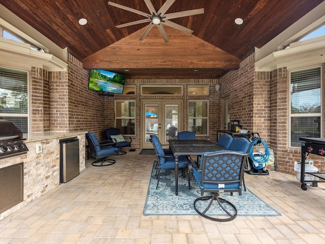 view of patio / terrace with ceiling fan, an outdoor kitchen, french doors, and a grill