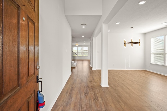 entryway featuring hardwood / wood-style flooring and a notable chandelier