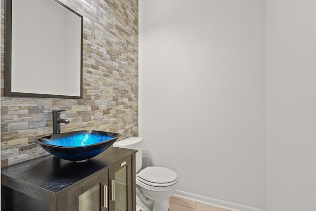 bathroom with tasteful backsplash, tile patterned floors, vanity, and toilet