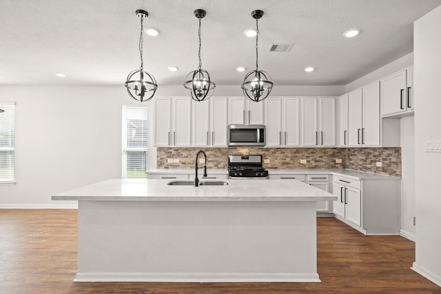 kitchen featuring sink, white cabinetry, stainless steel appliances, and a kitchen island with sink