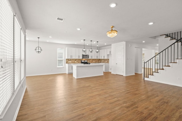 unfurnished living room with light hardwood / wood-style flooring and an inviting chandelier