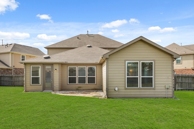 rear view of property featuring a lawn