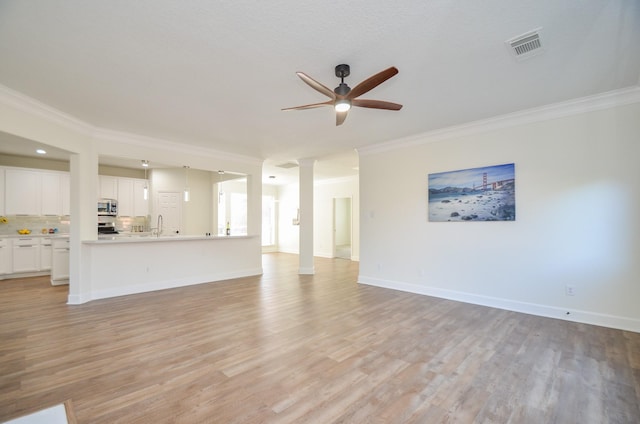 unfurnished living room with sink, light hardwood / wood-style flooring, ceiling fan, and ornamental molding