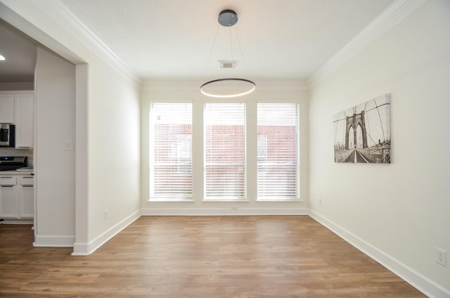 unfurnished dining area featuring light hardwood / wood-style floors and ornamental molding