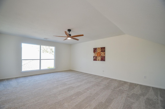 empty room featuring ceiling fan, light carpet, and vaulted ceiling