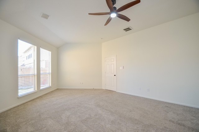 carpeted spare room with vaulted ceiling and ceiling fan