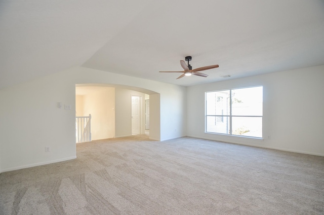 carpeted spare room featuring ceiling fan and lofted ceiling