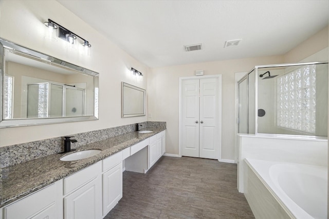 bathroom featuring vanity, hardwood / wood-style floors, and plus walk in shower