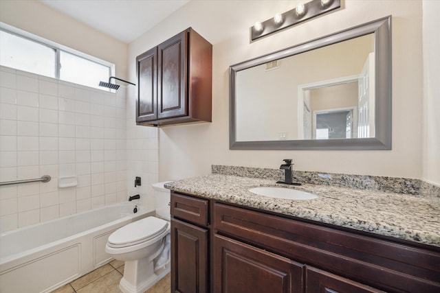 full bathroom with tile patterned floors, tiled shower / bath, vanity, and toilet