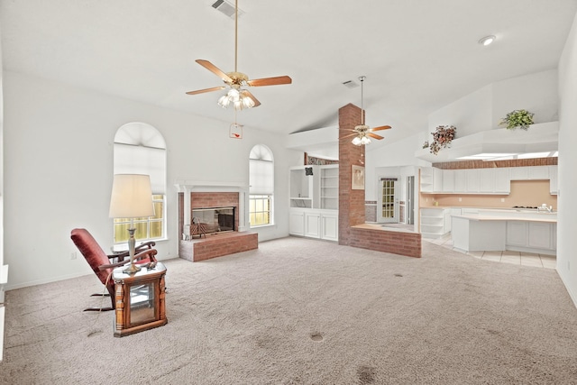 living room featuring ceiling fan, high vaulted ceiling, light carpet, and a fireplace