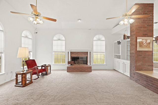 carpeted living area with a fireplace and ceiling fan