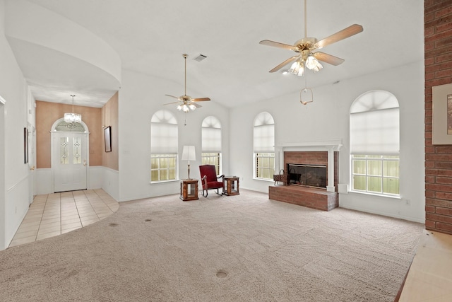 unfurnished living room featuring a fireplace, ceiling fan, visible vents, carpet, and tile patterned flooring