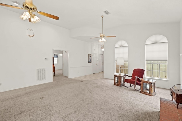 living area featuring visible vents, a ceiling fan, carpet, and vaulted ceiling