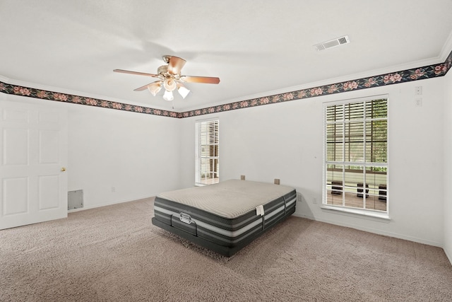 bedroom with visible vents, a ceiling fan, crown molding, and carpet