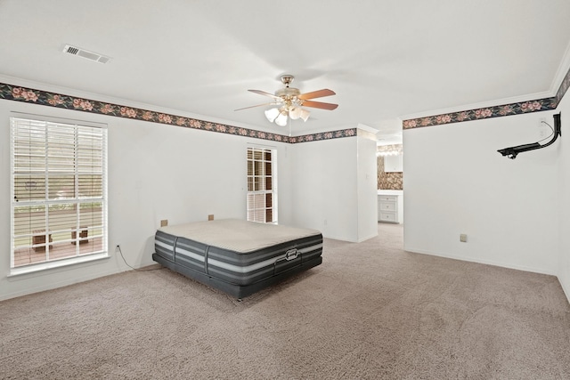carpeted bedroom featuring crown molding, visible vents, ceiling fan, and baseboards