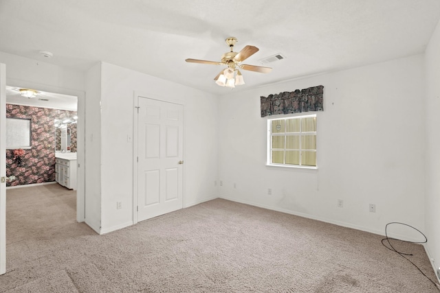 unfurnished bedroom featuring baseboards, visible vents, a ceiling fan, and carpet floors
