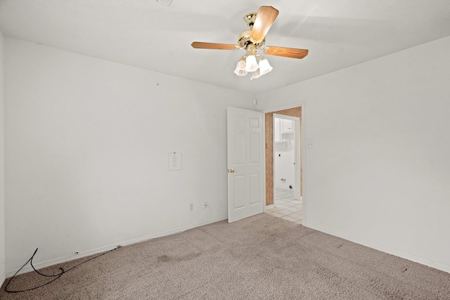 empty room with ceiling fan, light colored carpet, and baseboards