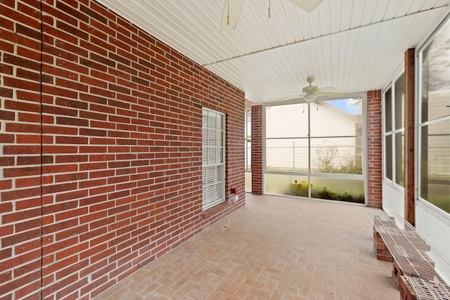 unfurnished sunroom featuring a ceiling fan