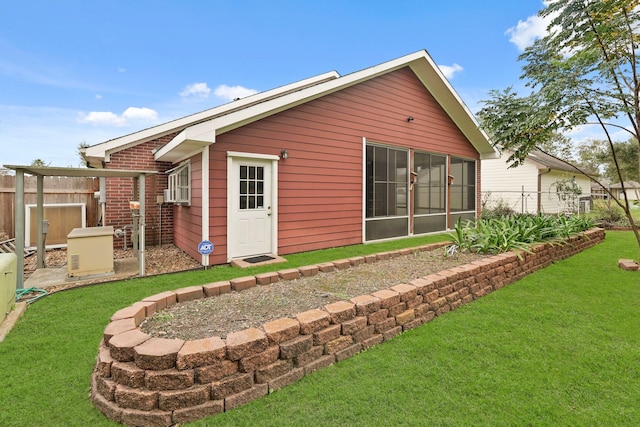 back of property with fence and a lawn