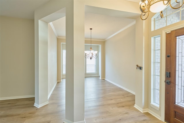 foyer entrance featuring a chandelier, crown molding, and light hardwood / wood-style flooring