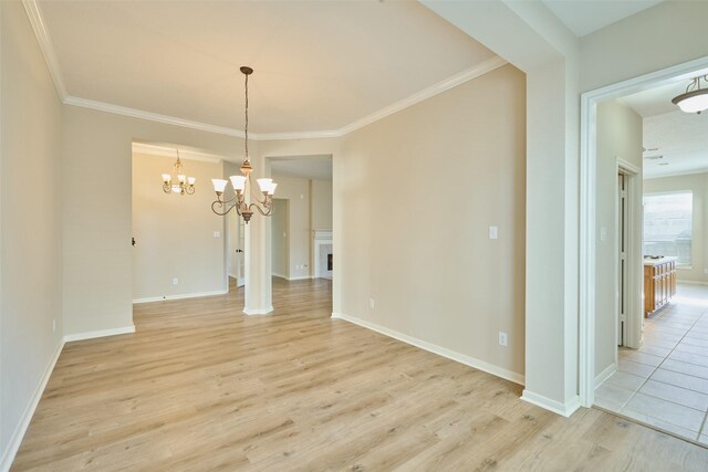 interior space with an inviting chandelier, ornamental molding, and light hardwood / wood-style flooring