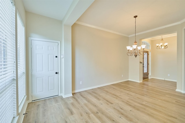 unfurnished room with light wood-type flooring, an inviting chandelier, and crown molding