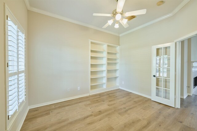 unfurnished room featuring built in shelves, ornamental molding, ceiling fan, and light hardwood / wood-style flooring