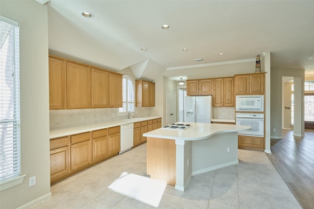 kitchen featuring white appliances, a healthy amount of sunlight, decorative backsplash, and a kitchen island