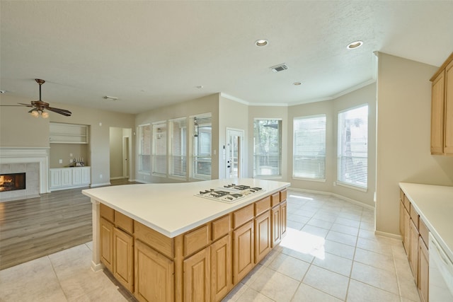 kitchen with a kitchen island, white appliances, a tile fireplace, and light tile patterned floors