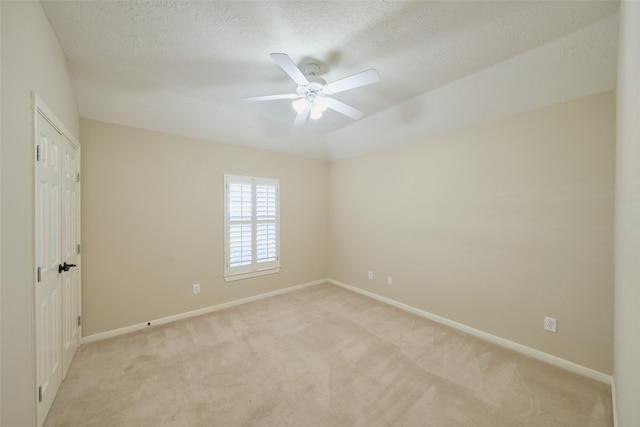 carpeted spare room with a textured ceiling and ceiling fan