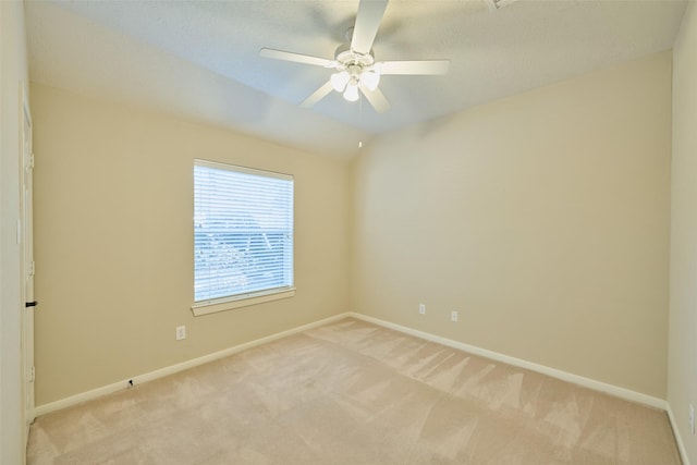 carpeted spare room featuring ceiling fan and vaulted ceiling