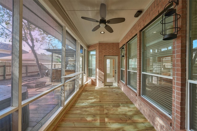 unfurnished sunroom with ceiling fan