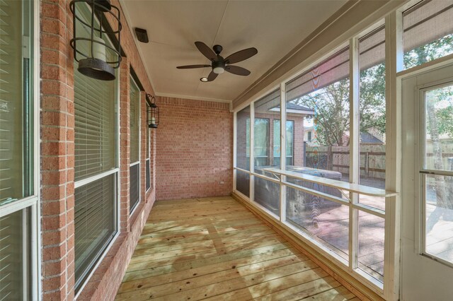 unfurnished sunroom with ceiling fan