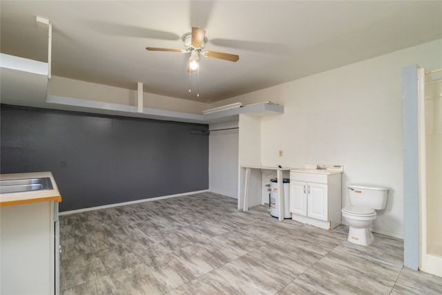 basement featuring ceiling fan and sink