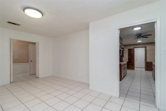 tiled empty room with ceiling fan