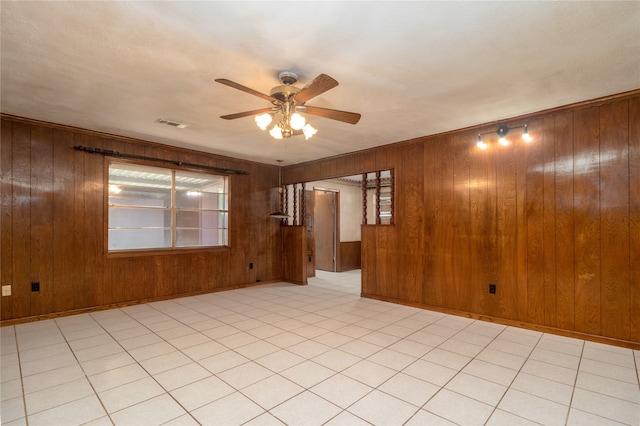 empty room featuring wooden walls and ceiling fan