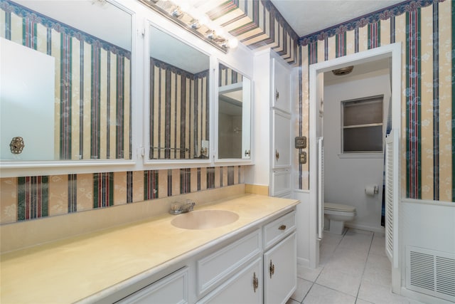 bathroom featuring tile patterned flooring, vanity, and toilet