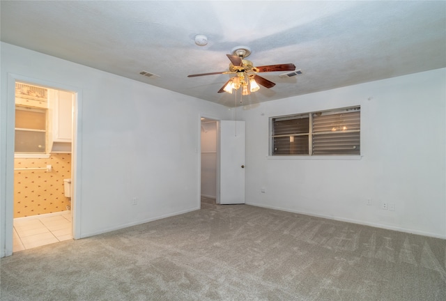 carpeted spare room featuring a textured ceiling and ceiling fan