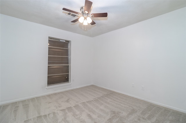 carpeted spare room featuring ceiling fan